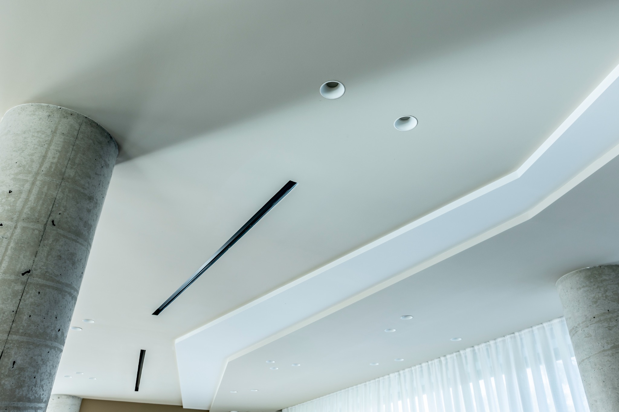 Controsoffitto completato con luci lineari e pilastro a vista