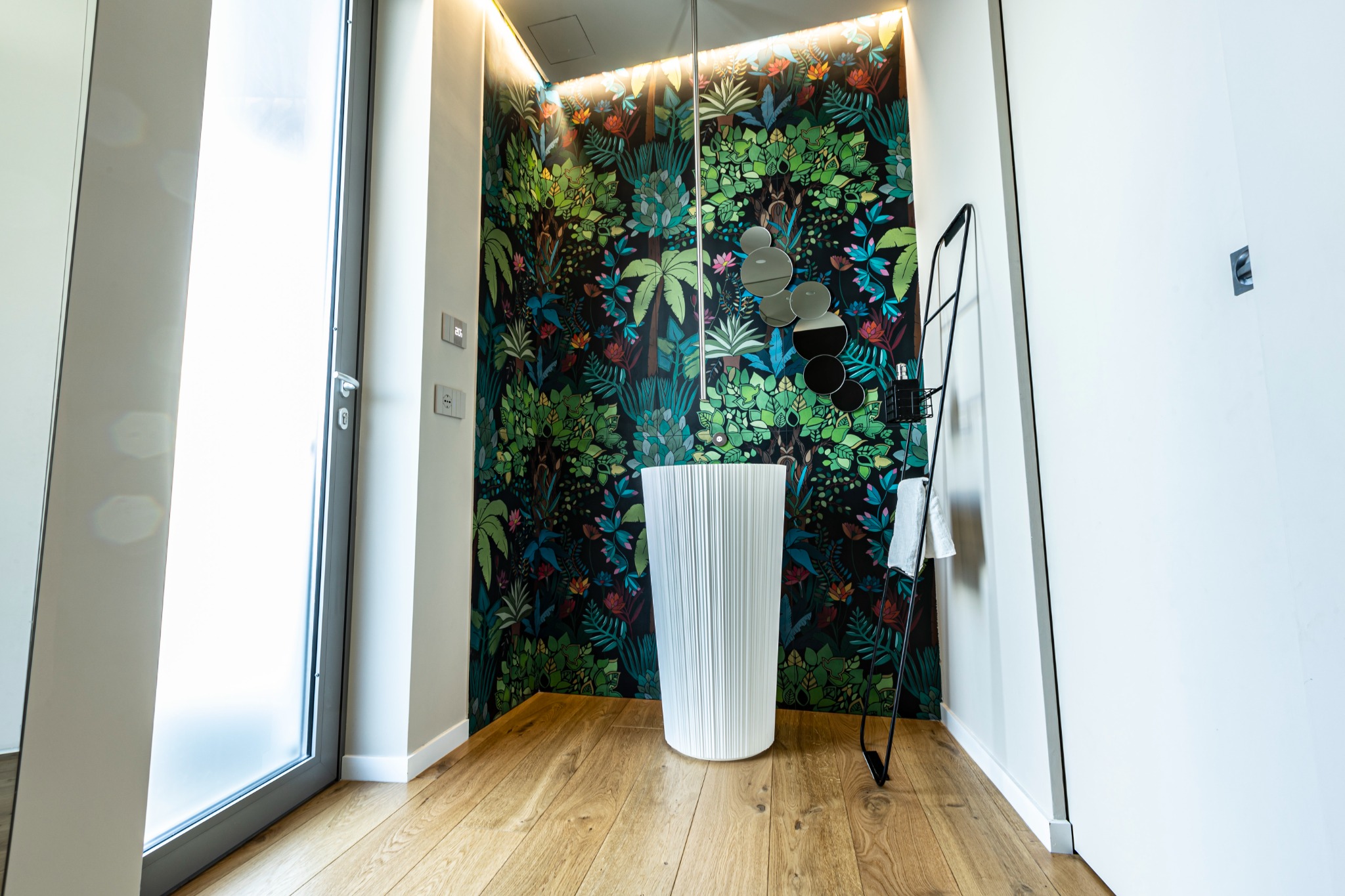 Parete con decorazione floreale e lavabo a colonna